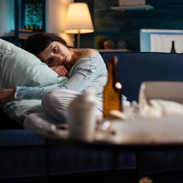 Anxious woman with depression laying on couch at home