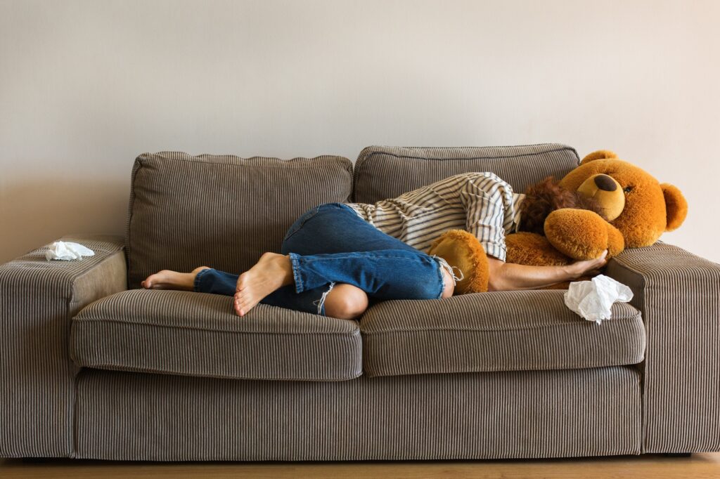Depressed young woman crying on the couch, stress, anxiety, loneliness